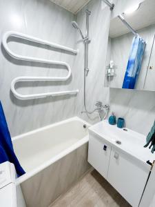 a bathroom with a white tub and a sink at 2-Room Apartment in Lahemaa Near the Sea in Loksa +20 photos
