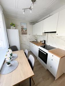 a kitchen with white cabinets and a wooden table at 2-Room Apartment in Lahemaa Near the Sea in Loksa