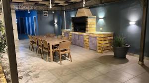 a dining room with a wooden table and a fireplace at The Mountain View in Ash Shāghūr