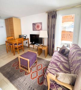 a living room with a couch and a table at Cozy Studio with Wellness in Goms in Blitzingen