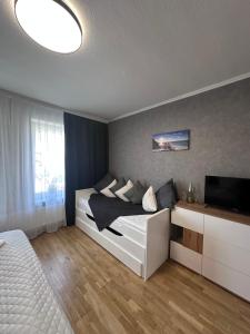 a bedroom with a bed and a flat screen tv at Ferienwohnung Waldblick in Harrislee