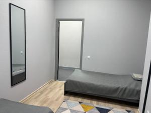a bedroom with a bed and a mirror at Astana Rooms in Astana