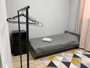 a small bedroom with a bed and a television at Astana Rooms in Astana