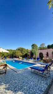 a swimming pool with two chairs and an umbrella at El Juneina Villas - Luxury Boutique Villas Near Valley of the Kings in Luxor