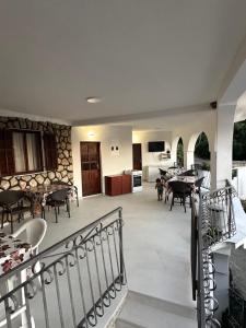 a balcony with tables and chairs and a kitchen at Apartmani Becic in Sutomore +40 photos