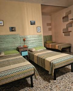 a room with three beds and a table with a lamp at Bricc e Foss in San Desiderio