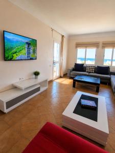 a living room with a couch and a tv on the wall at Spacious Apartment with views to sea and pool Kabila vista Families only in Marina Smir
