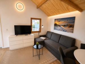 a living room with a couch and a flat screen tv at NicePlace4You Familien-Ferienhäuser an der polnischen Ostsee mit Pool in Dobiesławiec