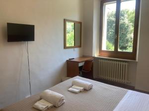 a bedroom with a bed and a desk and a television at Albergo Italia in Ancona
