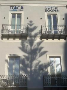a shadow of a building with balconies and a hotel at Itaca Porto Loft& Rooms in Milazzo