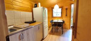 a kitchen with a refrigerator and a table in it at Jaskolcze Gniazdo in Dziwnówek