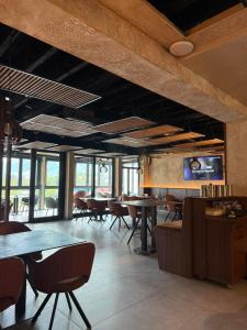 a dining room with tables and chairs and windows at Motel Gradina in Bosansko Grahovo