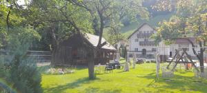 a barn in a yard next to a white building at Voinescu House - Natural Living & Eating in Şimon
