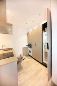 a kitchen with white cabinets and a refrigerator at Domus Halo F in Pamplona