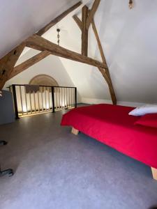 a bedroom with a red bed in a attic at Loft cosy 4 in city center in Saint-Benoît-sur-Loire