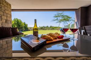 a table with glasses of wine and a plate of food at Sunshine maasai mara safari camp in Sekenani
