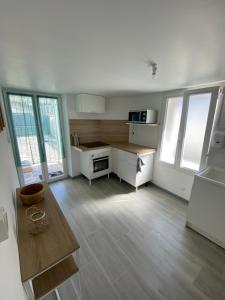 a kitchen with white cabinets and a wooden floor at Loft cosy 4 in city center in Saint-Benoît-sur-Loire