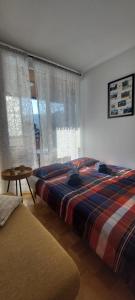 a bedroom with a large bed and a table at Apartma Rožmarin Bohinj in Bohinj
