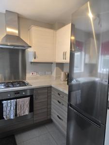 a kitchen with stainless steel appliances and wooden cabinets at Grace's Place in Milton in Milton