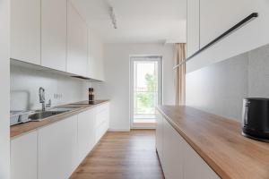 a kitchen with white cabinets and a wooden counter top at Helskafoka2 in Hel