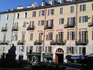 a large building with cars parked in front of it at Attic Hostel Torino in Turin