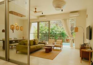 a living room with a green couch and a table at Aura Stays L8 in Vagator