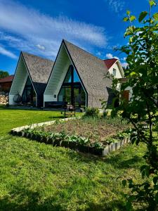 a house with a garden in front of it at Шале WeLKoMe in Verkhovyna