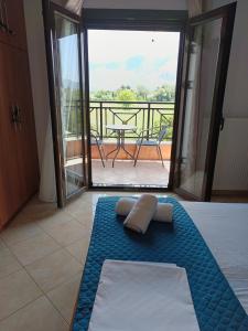 a room with a bed and a balcony with a table at Villa Eleni in Kypséli