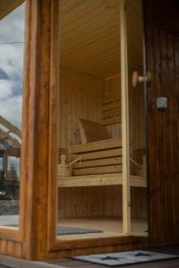 a reflection of a wooden sauna in a mirror at Bizon Cabin in Albeștii de Muscel