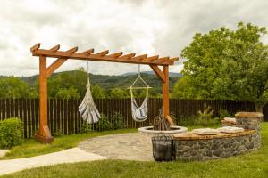 a wooden pergola and a fire pit in a yard at Bizon Cabin in Albeștii de Muscel +91 photos