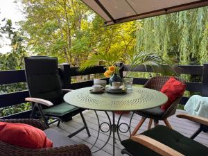 eine Terrasse mit Tisch und Stühlen auf einem Deck in der Unterkunft itzgrundperlchen in Untermerzbach + 12 Fotos