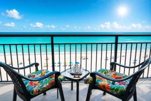 a balcony with two chairs and a table and the beach at New ! Ocean Reef Resort-Unique Renovated Oceanfront Condo -Free parking - Amazing pools & Views in Myrtle Beach