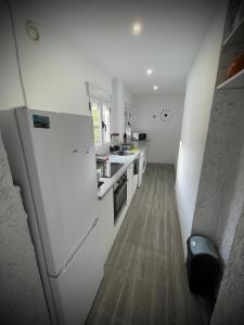 a kitchen with white appliances and a wooden floor at A vacation by the sea in Puerto de Sagunto