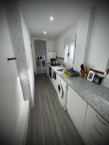 a kitchen with a sink and a washing machine at A vacation by the sea in Puerto de Sagunto