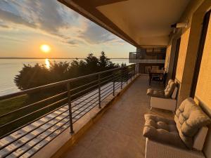 a balcony with a view of the ocean at sunset at Apartament Summerland Mamaia Nord in Mamaia