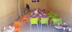 a room with a long table and colorful chairs at Camping Imdghas in Tilmi