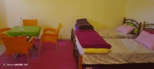 a room with two beds and a table and chairs at Camping Imdghas in Tilmi