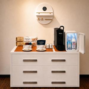 a white dresser with cups on top of it at UTOPIA "The Art of Bed & Breakfast" in Marigliano