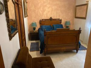 a bedroom with a bed with blue pillows and a mirror at Vintage Apartment in Vila Nova de Milfontes