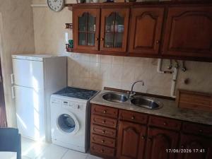 a kitchen with a sink and a washing machine at Vintage Apartment in Vila Nova de Milfontes