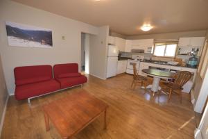 a living room with a red couch and a table at Equus Acres in Boston Bar