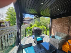 a patio with a couch and chairs on a balcony at Cozy and comfortable home - Living room and Kitchen is shared in Pickering