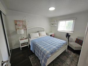 a bedroom with a bed and a chair and a window at Cozy and comfortable home - Living room and Kitchen is shared in Pickering
