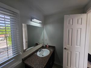 a bathroom with a sink and a mirror at Cozy and comfortable home - Living room and Kitchen is shared in Pickering