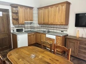 a kitchen with wooden cabinets and a wooden table at Esencia plaza in Hornos
