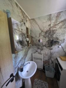 a bathroom with a sink and a marble wall at apartmaji Lejla in Vipava +37 photos