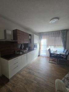 a kitchen with white cabinets and a table in a room at apartmaji Lejla in Vipava