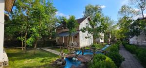 a house with a pond in the yard at Gabala Semerana Hotel Cottage in Gabala