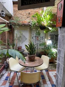 a patio with a table and chairs and plants at Hostal Casa Las Tías in Medellín