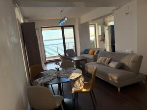 a living room with a couch and a table and chairs at Apartament Summerland Mamaia Nord in Mamaia